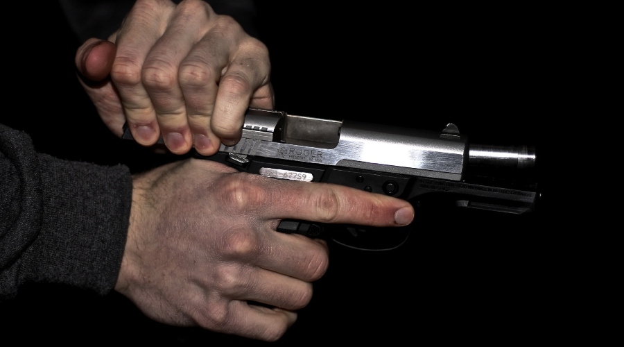 Mužské ruky držia zbraň